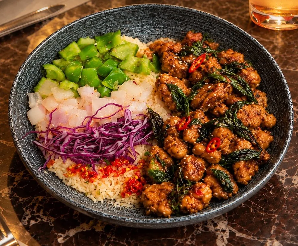 Thai basil chicken bowl over rice with fresh vegetables