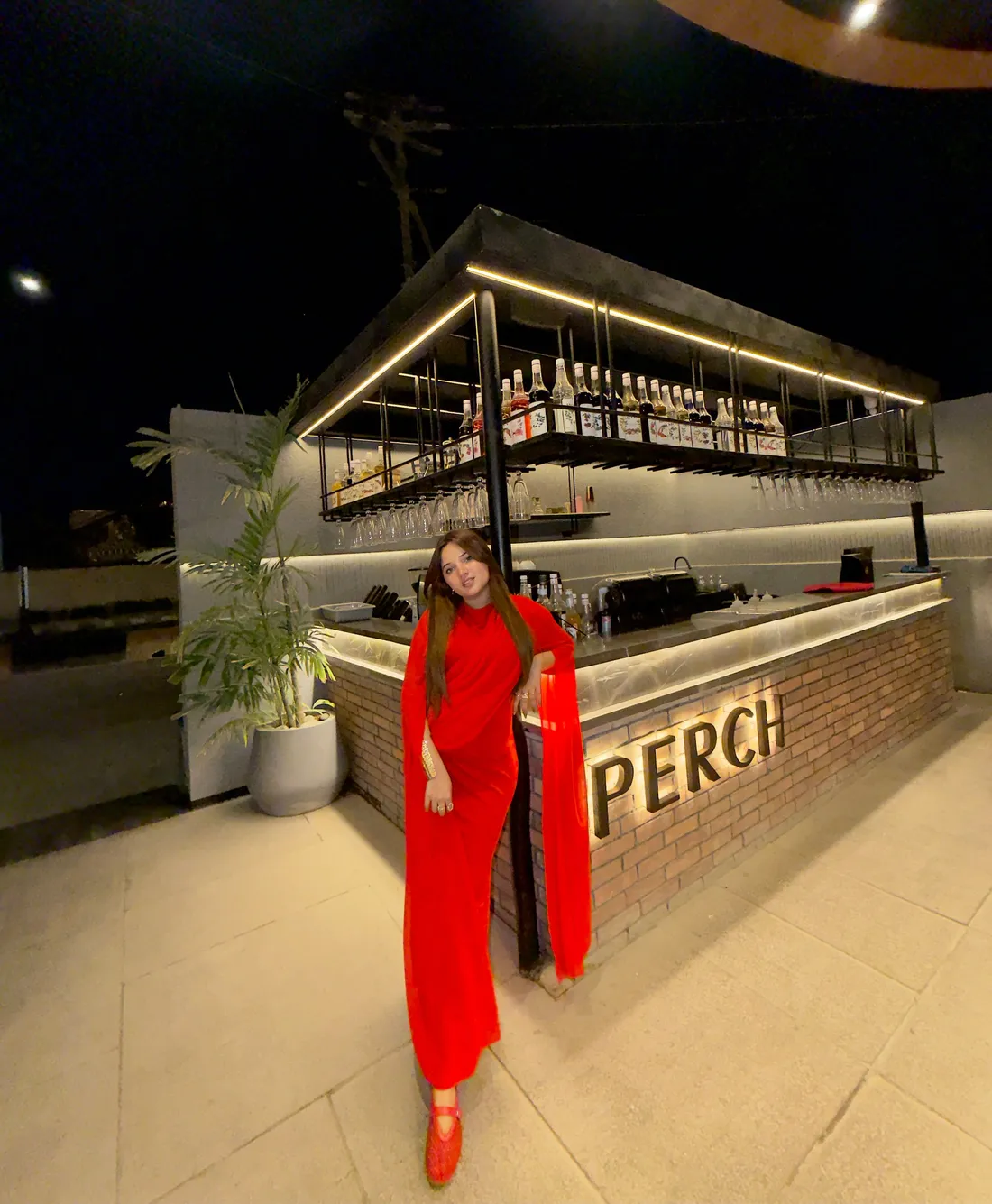 Guest at the brick bar beside the Perch sign